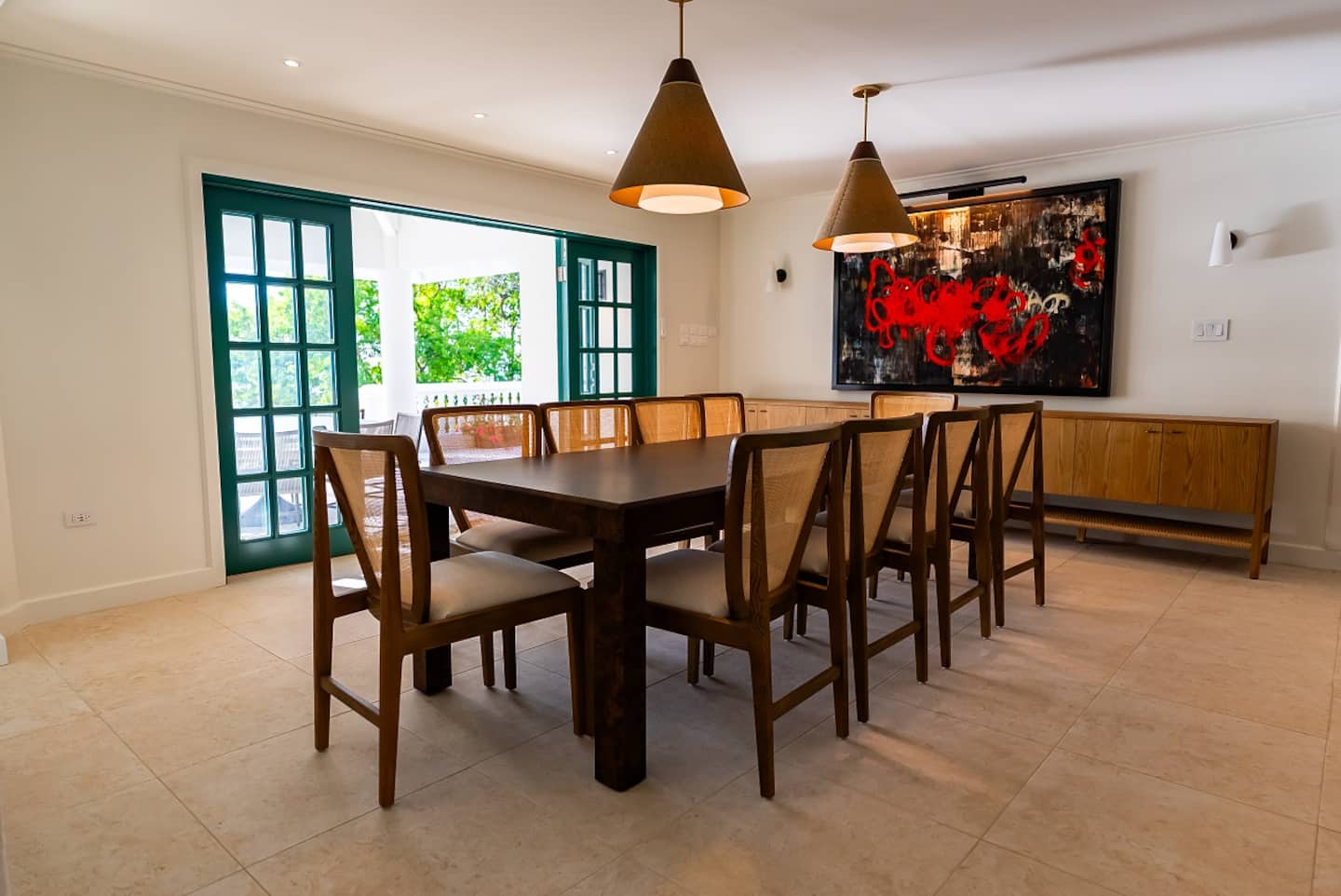 Dining table with wooden chairs and colourful artwork